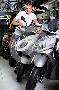 Portrait of adult man purchaser choosing motorbike