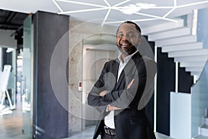 Portrait of adult mature african american boss, businessman inside office building smiling and looking at camera, senior