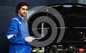 Portrait Adult Professional handsome caucasian male mechanic wearing uniform, holding laptop for fix, repair, check, inspect car