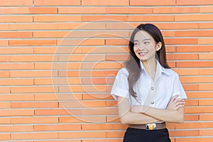 Portrait of an adult Thai student in university student uniform. Asian beautiful girl standing smiling happily and confidently