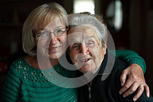 Portrait of an adult woman in an embrace with her old mother. Love.