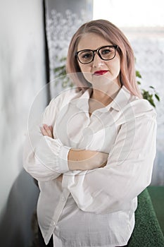 Portrait of an adult woman entrepreneur with grayish hair in a managerial position, dressed in a white blouse and busy working in