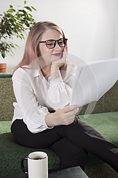 Portrait of an adult woman entrepreneur with grayish hair in a managerial position, dressed in a white blouse and busy working in