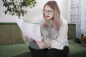 Portrait of an adult woman entrepreneur with grayish hair in a managerial position, dressed in a white blouse and busy working in