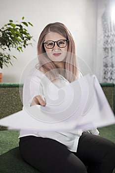 Portrait of an adult woman entrepreneur with grayish hair in a managerial position, dressed in a white blouse and busy working in