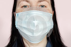 Portrait of an adult woman wearing a medical face mask protecting against respiratory diseases transmitted by airborne