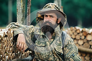 Portrait of adventure serious man extreme explorer. Man hunter in camouflage outdoor. Brutal hunter, bearded man in the