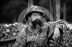 Portrait of adventure serious man extreme explorer. Man hunter in camouflage outdoor. Brutal hunter, bearded man in the