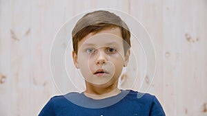 Portrait afraid with fright looking to camera in light studio. Close up scared boy face. Surprased teenager on light