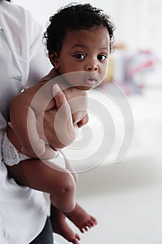 Portrait of african american baby girl on hand of mother