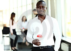 Portrait of African American business man with executives working in background