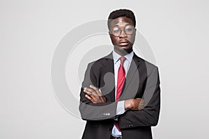 Portrait of African American business man with folded arms, isolated on greybackground