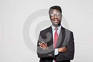 Portrait of African American business man with folded arms, isolated on greybackground