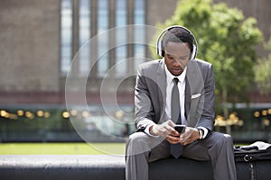Portrét americký podnikateľ načúvanie na hudba slúchadlá vonku 