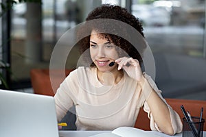 Portrait of african american curly haired customer service woman working on call center
