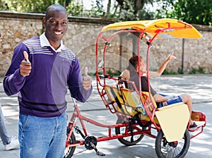 Portrait of African American driver of pedicab offering touristic tour