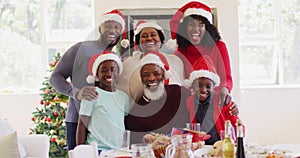 Portrait of african american family in santa hats smiling together at home