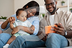 Portrait of african american family using cell phone at home