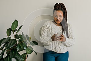 Portrait of African American female student dressed casually holding mobile phone and typing messages and communicating