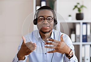 Portrait of african american guy in headset talking and gesturing