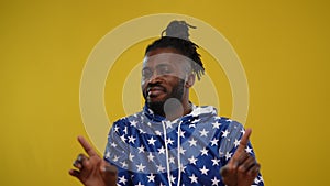 Portrait of African American handsome man denying gesturing at yellow background. Confident proud guy in hoodie with US