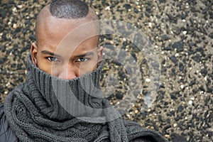 Portrait of an african american male fashion model with gray scarf covering face