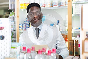 Portrait of an african american male pharmacist standing in the sales hall of a pharmacy