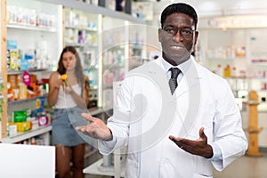 Portrait of an african american male pharmacist standing in the sales hall of a pharmacy