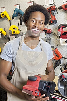 Portrait of an African American male store clerk holding electronic tool