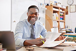 Portrait of African American male teacher working at desk