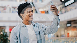 Portrait african american man guy student male indoors using mobile app phone waving hello talking video call conference
