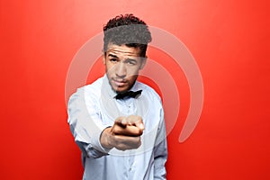 Portrait of African-American man  pointing at viewer on color background