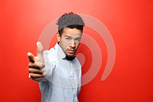 Portrait of African-American man  pointing at viewer on color background