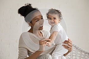 Portrait of African American mom play with toddler daughter