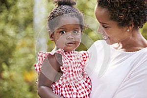 Portrait of African American mother holding baby daughter