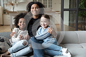 Portrait African American mother hugging two little daughters, multiracial family