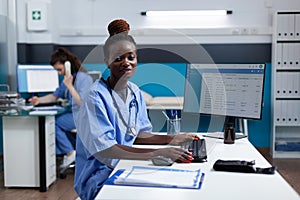 Portrait of african american pharmacist nurse typing medical prescription