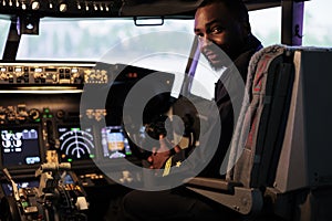 Portrait of african american pilot using dashboard command in cabin