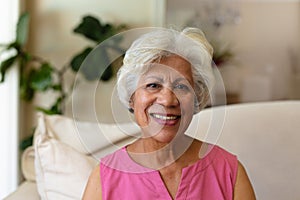 Portrait of african american senior woman smiling sitting on the couch at home