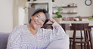 Portrait of african american senior woman smiling sitting on the couch at home