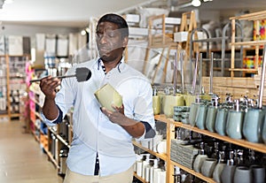 African American shopper choosing bathroom accessories in store