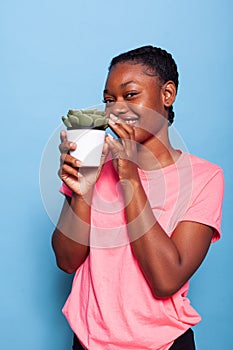 Portrait of african american student enjoying gardening hobby holding flower pot