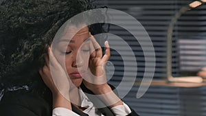 Portrait of African American woman in business suit, suffers from overwork and headache. Businesswoman posing at