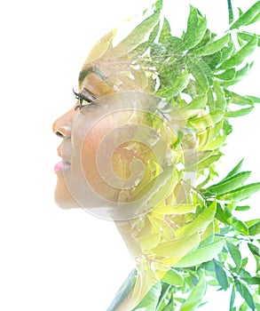 A portrait of an African American woman combined with an image of green leaves in a double exposure technique.