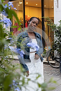 Portrait of African American woman dressed in white and denim jacket, getting to know Europe, Ferrara. Italy