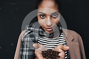 Portrait of african american woman holding coffee beans in her palms