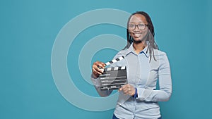 Portrait of african american woman holding film slate board