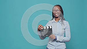 Portrait of african american woman holding film slate board