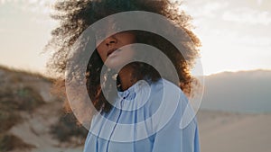 Portrait african american woman with lush curly hair at desert gloomy summer.