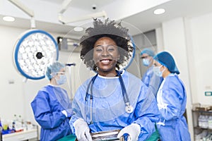 Portrait of African American woman surgeon standing in operating room, ready to work on a patient. Female medical worker in